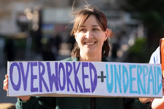 A junior doctor on strike in front of the hospital she works in London