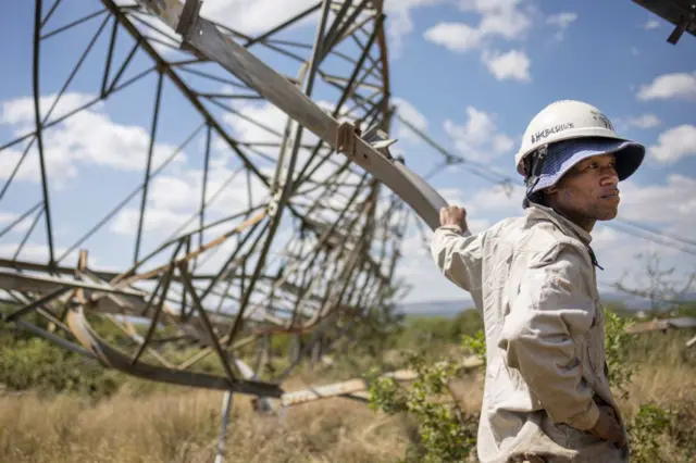 Worker leaning on pylon in South Africa - 12 April 2023