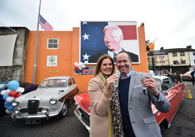 Joe Blewitt and his wife Deirdre underneath a mural of Joe Biden in Ballina, County Mayo, Ireland, in 2020