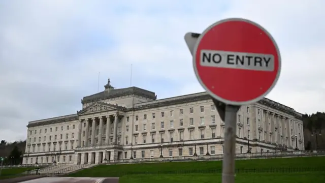 Image of the Northern Ireland Assembly building with a "no entry" sign in front of it