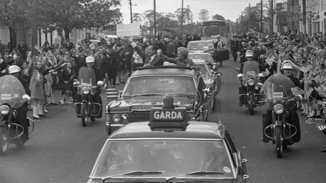 Black and white photo of Richard Nixon in a motorcade