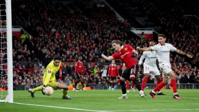 Sevilla's Bono makes a save as Gonzalo Montiel and Manchester United's Marcel Sabitzer look on