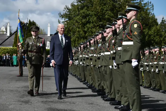 Joe Biden inspects troops while visiting the Irish President's official residence Áras an Uachtaráin