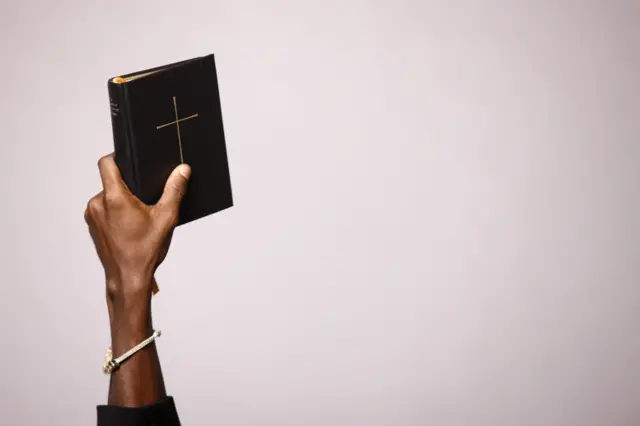 Stock image of a man holding a Bible