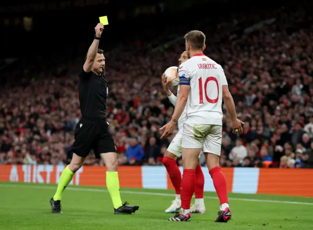 Sevilla's Ivan Rakitic is shown a yellow card by referee Felix Zwayer