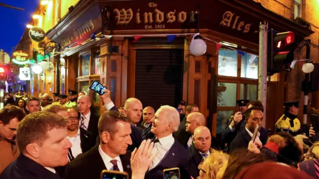 US President Joe Biden takes a selfie outside a pub