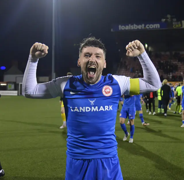 Larne captain Tomas Cosgrove celebrates the league title win.