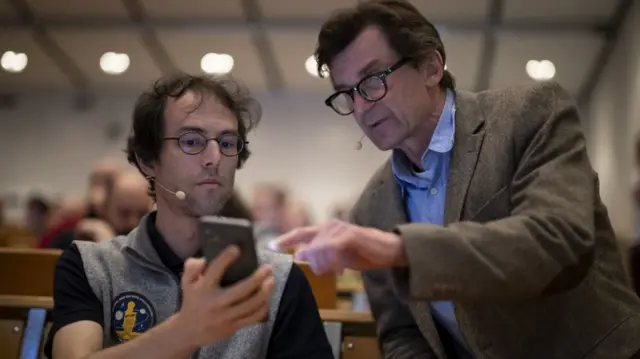 Project scientist Andre Galli and Peter Wurz, Director of Physics Institute of the University of Bern, chat during the broadcast of the the second launch attempt of the Ariane 5 rocket