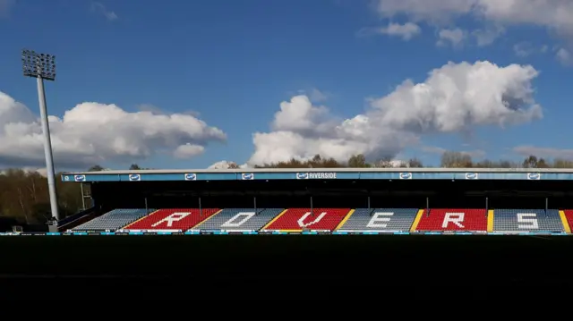 Shadows cascade over the Ewood Park pitch