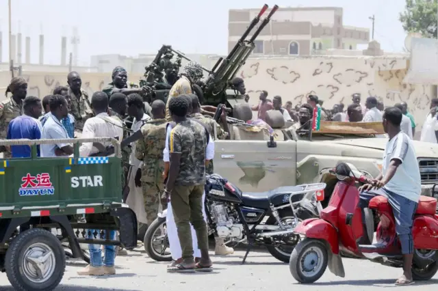 Sudanese greet soldiers, loyal to army chief Abdel Fattah al-Burhan, in the Red Sea city of Port Sudan on 16 April 2023