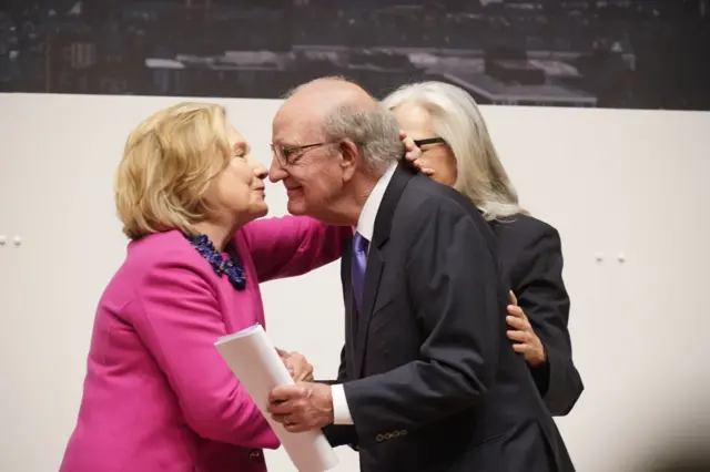 Hillary Clinton embraces Senator George Mitchell, who chaired the talks in 1998