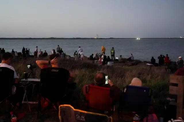 People gather before SpaceX's Starship lifts off from the company's Boca Chica launchpad