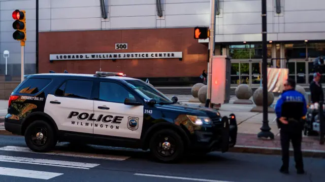 Wilmington police officers stand guard in front of the Leonard L Williams Justice Center, where the trial is taking place