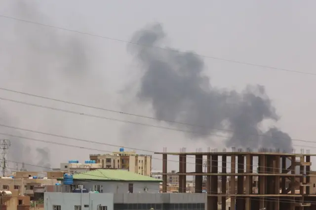 Smoke billows behind residential buildings in Khartoum on April 17, 2023