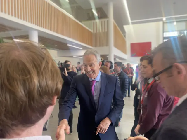 Sir Tony Blair shakes hands with a young man