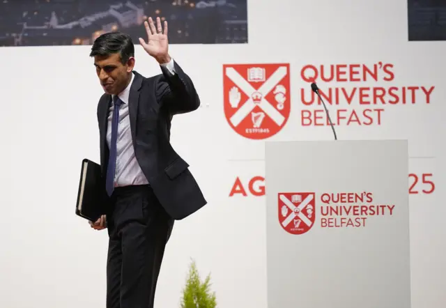 Rishi Sunak waves as he leaves the stage at Queen's University