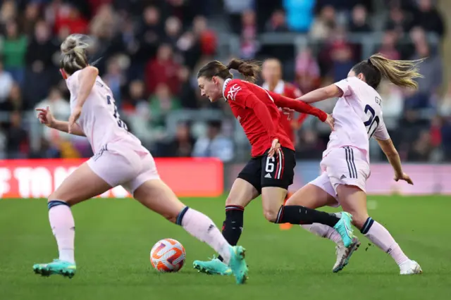 Man Utd andArsenal players challenge for the ball.