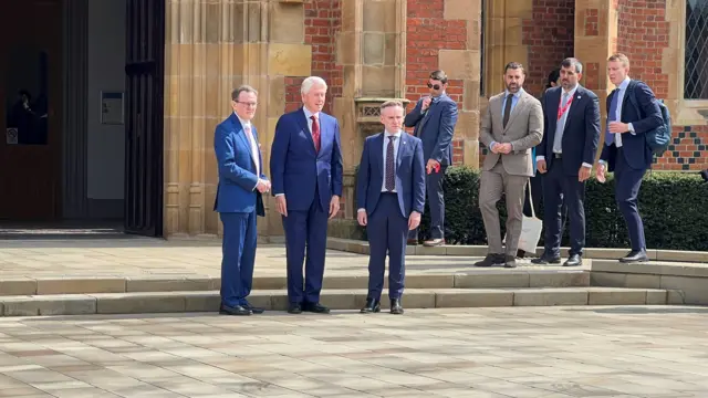 QUB vice-chancellor Ian Greer, former US President Bill Clinton and Ryan Feeny from Queen's stand in front of the Lanyon Building