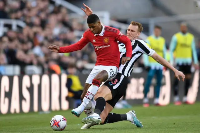 Manchester United's English striker Marcus Rashford is tackled by Newcastle United's English defender Dan Burn