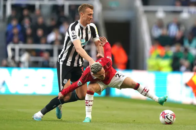 Newcastle United's Dan Burn and Manchester United's Antony battle for the ball