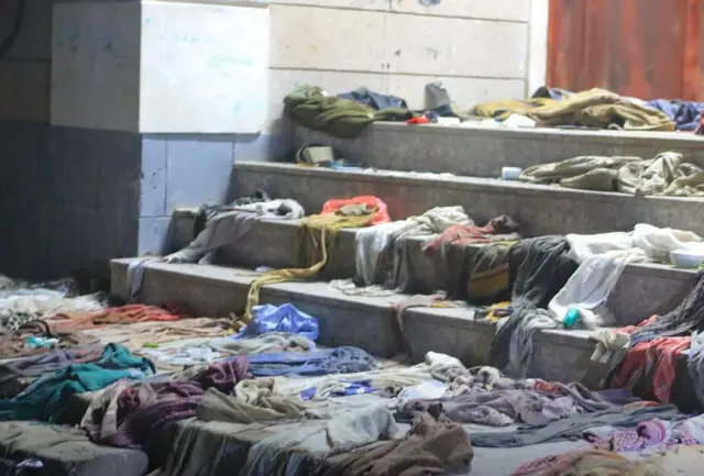 Clothes piled on the steps outside the school