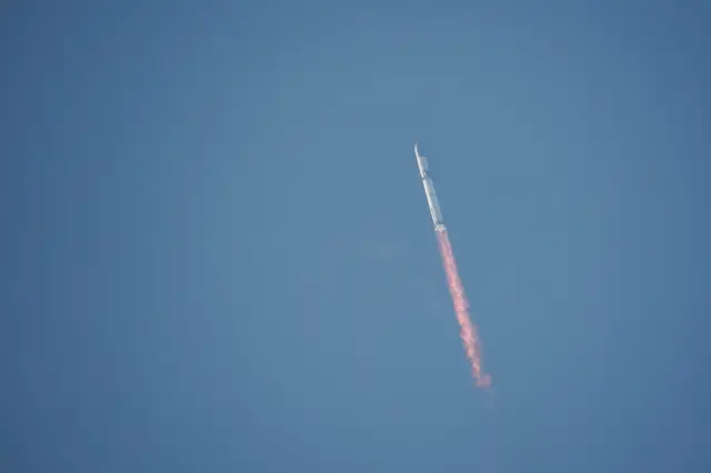 Starship atop its powerful Super Heavy rocket speeds through the sky