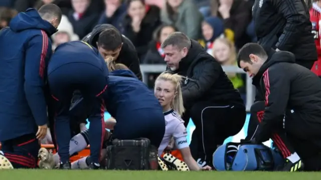 Arsenal defender Leah Williamson receives treatment on the pitch at Leigh Sports Village