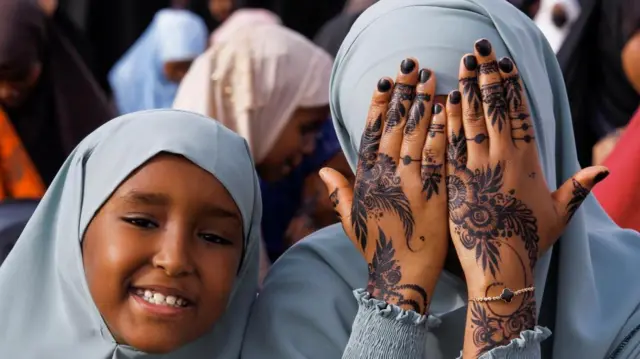 A woman displays her henna decoration before attending Eid al-Fitr prayers, marking the end of the fasting month of Ramadan, at the Masjid Salaam grounds in Nairobi, Kenya - 21 April 2023