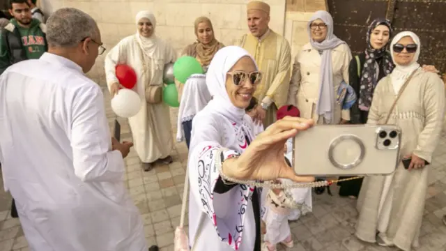 People take photos after performing the Eid al-Fitr prayer during the first day of the Eid al-Fitr holiday at Saheb Ettabaa Mosque in Tunis, Tunisia on April 21, 2023