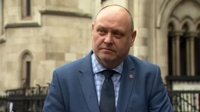 Dave Penman stands outside the High Court in a suit