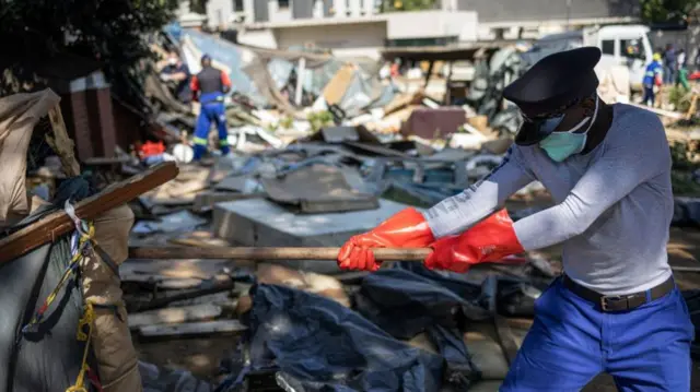 A police man destroying makeshift camps outside the UNHCR building in Pretoria, South Africa - 21 April 2023