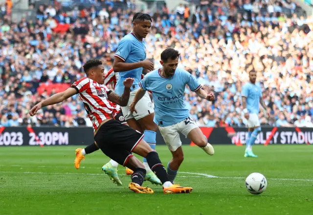 Bernardo Silva goes down under the challenge of Sheffield United's Daniel Jebbison