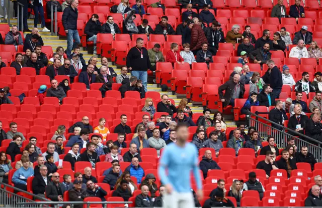 Fans inside the stadium surrounded by empty seats