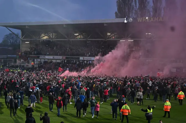 Fans celebrate on the pitch