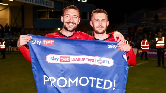 Craig Clay and Tom James of Leyton Orient hold promoted flag