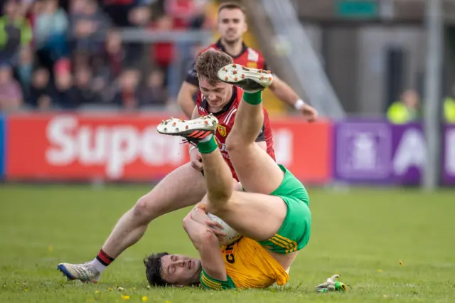 Donegal's Daire O’Baoill holds on to the ball as Danny Magill moves in