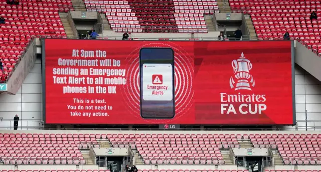 A warning of the 3pm Emergency Text Alert on the big screen ahead of the Emirates FA Cup semi-final match at Wembley Stadium