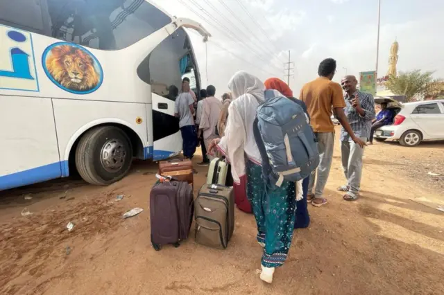 People board a bus in Khartoum