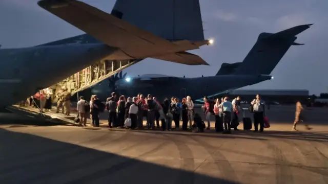 Italian citizens board an Italian Air Force C130 aircraft during their evacuation from Khartoum