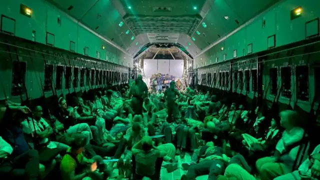 Spanish diplomatic personnel and citizens wait to disembark from a military plane after they were evacuated from Sudan