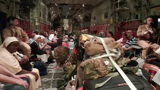 Italian citizens are boarded on an Italian Air Force C130 aircraft during their evacuation from Khartoum, Sudan