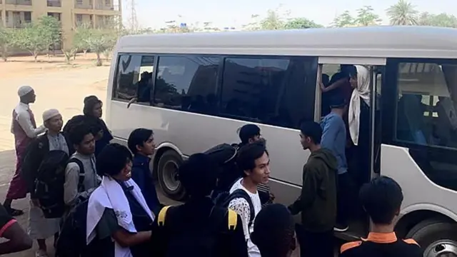 A handout photo made available by the Indonesian embassy shows Indonesian citizens bording a bus in Khartoum