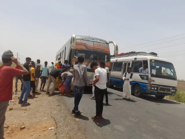 Young people standing outside a bus