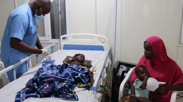 An MSF nurse attends to a critically ill child admitted to the emergency room at the Nilefa kiji nutrition centre. Nigeria, April 2023.