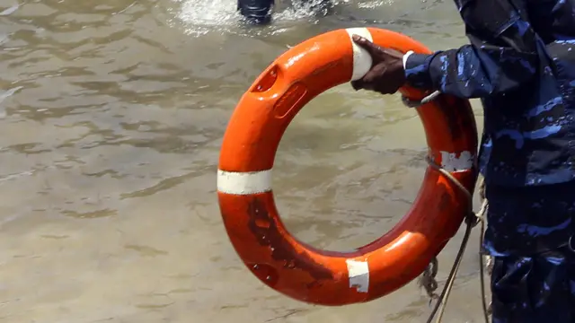 A coastguard holding a lifebuoy ring in Libya - archive shot