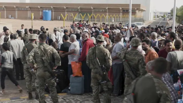 Crowds queueing to board a military aircraft at Wadi Seidna airport in Sudan