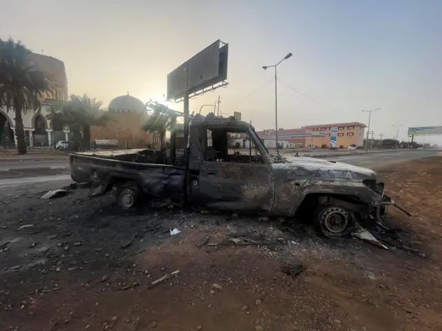 A burned vehicle is seen in Khartoum