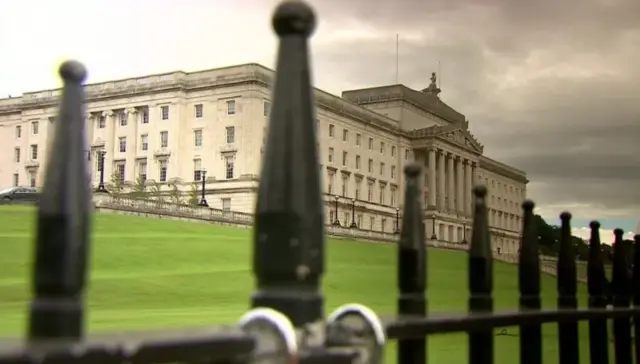 Stormont's Parliament Buildings seen through fence railings