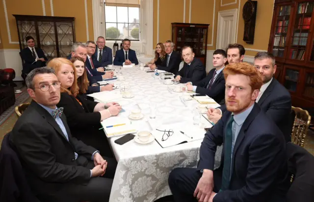 Stormont politicians, the Northern Ireland Secretary and his officials sit around a table at Hillsborough Castle