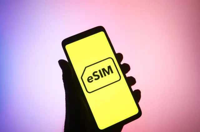 In this photo illustration, eSIM word, name of an embedded integrated programmable SIM card